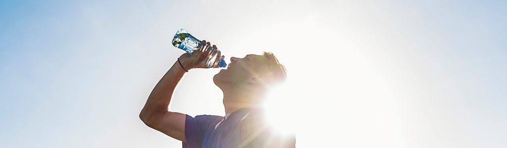 man drinking water in sun
